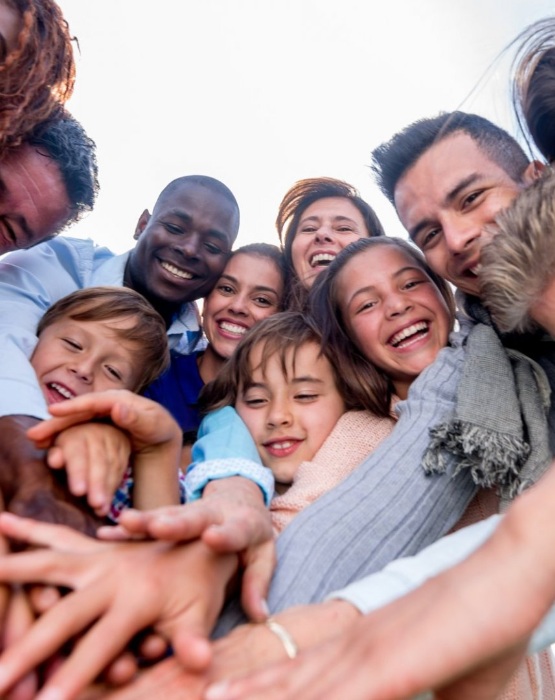 a group of people smiling putting their hands in a pile