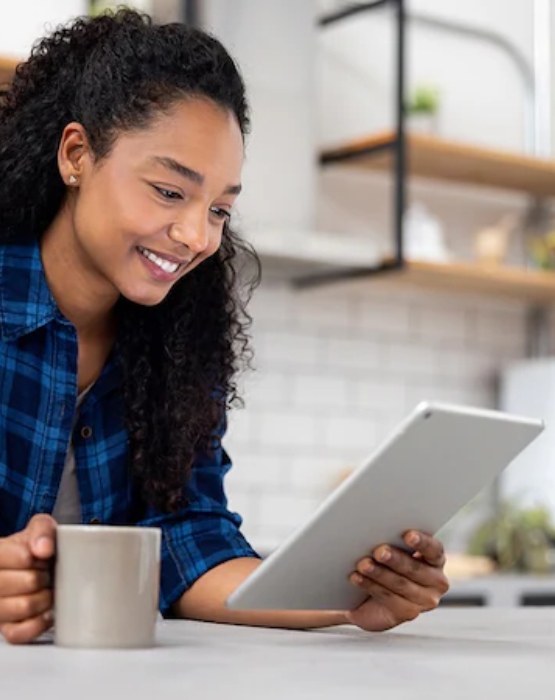 a woman in her kitchen viewing her tablet