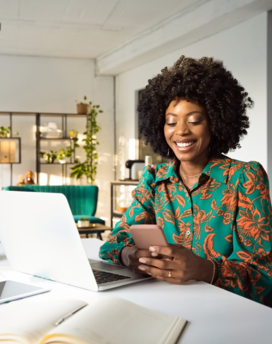 woman sitting at her desk holding her mobile phone
