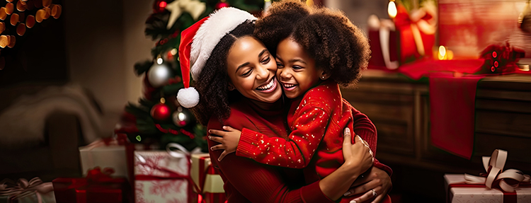 Mother and daughter hugging in front of holiday background.